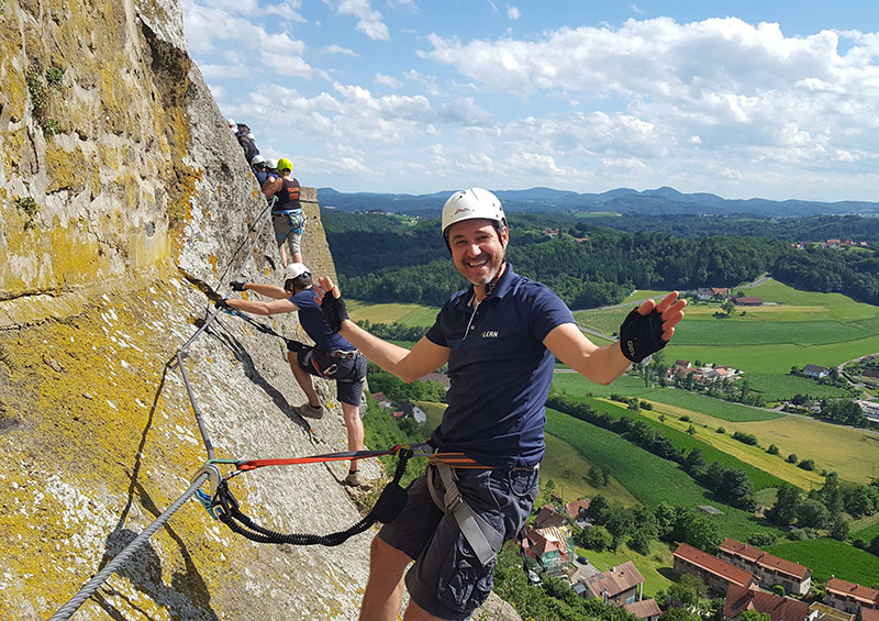 Klettersteig Challenge 2026 - ein Kletterer am Burgfelsen winkt in die Kamera